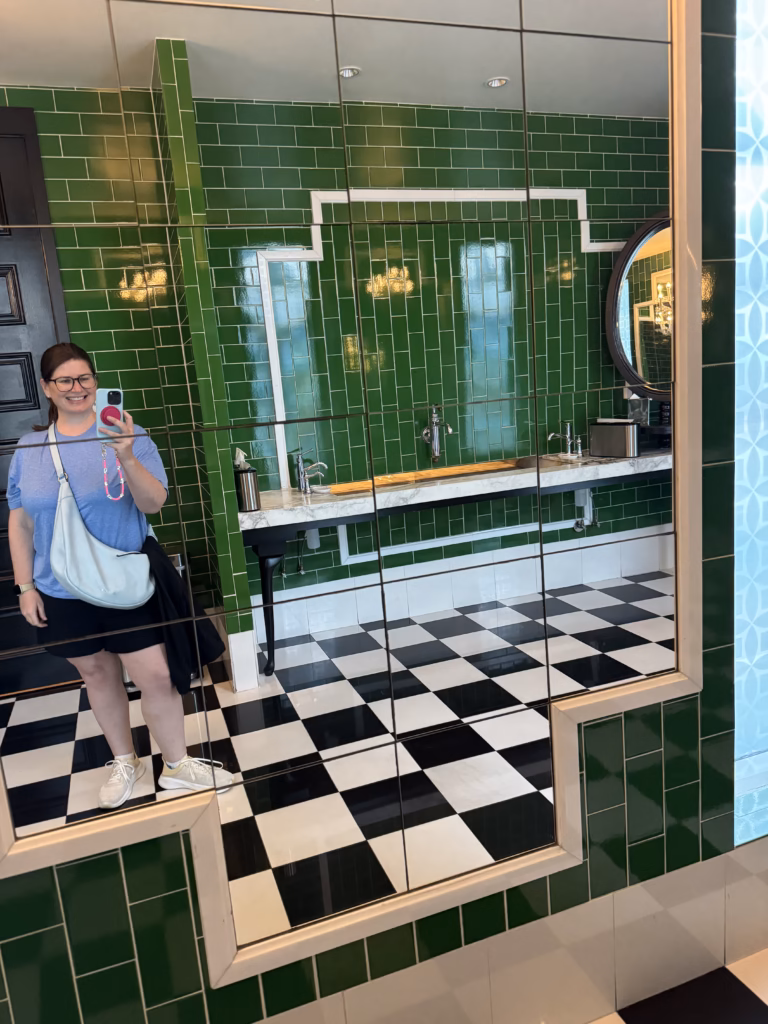 Tiled green wall and checkerboard floor at Viceroy Santa Monica lobby bathroom