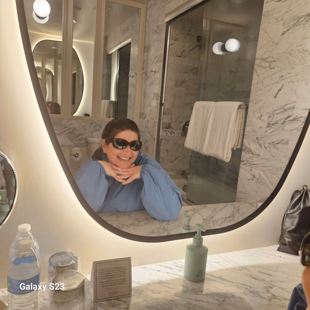 Woman sitting in stool at vanity in Viceroy Santa Monica room